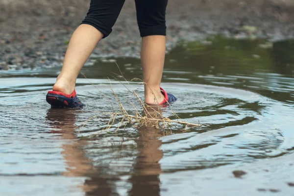雨后孩子们的脚在泥泞的水坑里走路 — 图库照片
