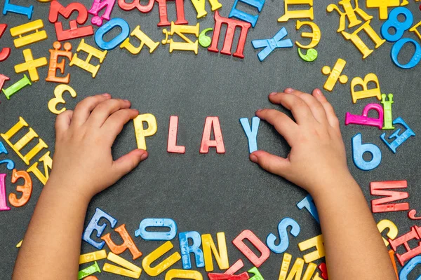 Çocuğun Eli Çok Renkli Plastik Harflerden Oyun Kelimesini Çıkardı — Stok fotoğraf