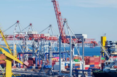 Lifting port cranes and sea containers in the cargo seaport.