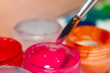 Pembe püsküllü küçük bir kavanoz gouache..