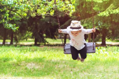 Açık parkta oynayan çocuk, salıncakta sallanan mutlu küçük kız..