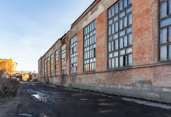 Old decaying factory building in disrepair, danger of wall collapse.