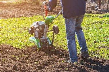 Çiftçi adam ekiciyle toprağı sürüyor toprağı ekime hazırlıyor..