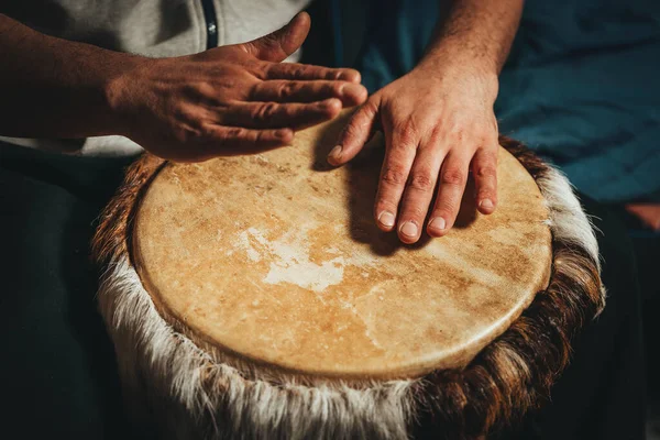 Hands of a drummer playing the ethnic percussion musical instrument djembe.