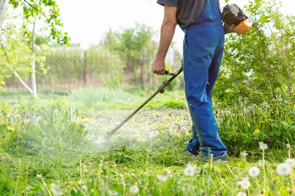 Tuinman Maait Het Gras Met Een Trimmer Voorjaarstuin — Stockfoto