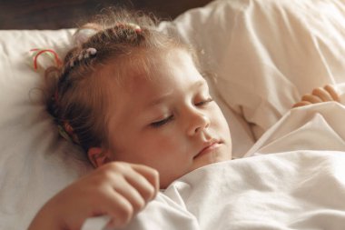 Küçük tatlı hasta kız yatağında uyuyor..