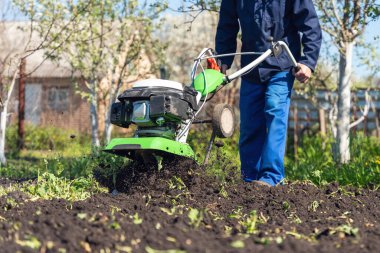 Çiftçi adam ekiciyle toprağı sürüyor toprağı ekime hazırlıyor..