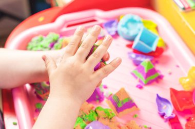 Çocuk çok renkli kinetik kumdan figürler yontuyor, el becerileri geliştiriyor..