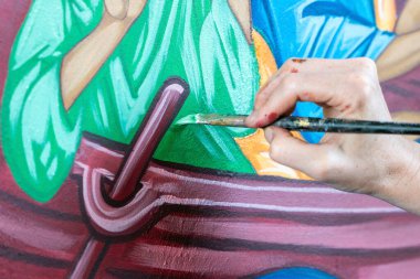 Ressamın eli resmi yeşil boyayla boyar..