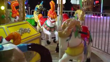 Atlı parlak bir atlıkarınca, gece eğlencesi, fuarda ışıklarla çocuk salıncakları