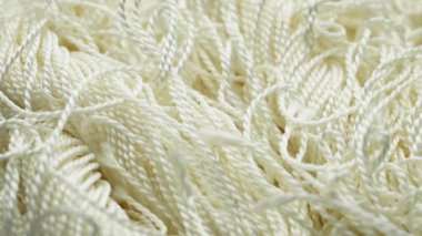 Materyalin karmaşık dokularını ve desenlerini gösteren sentetik beyaz lifin yakın çekimi.
