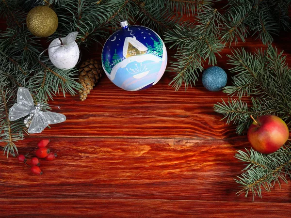 Christmas toys and fir-tree branches on wooden table — Stock Photo, Image