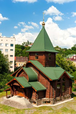 Modern binaların ahşap tapınağı, kentsel çevrenin arka planına ve mavi gökyüzüne karşı beyaz bulutlu