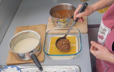 Paris, Fransa - 02 14 2021: Et, ıspanak, domates ve beşamel ile lazanya hazırlama