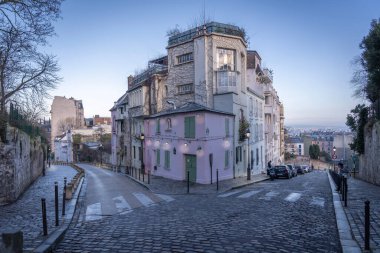 Paris, Fransa - 02 26 2021: Montmartre bölgesi. Pembe ev gün doğumunda