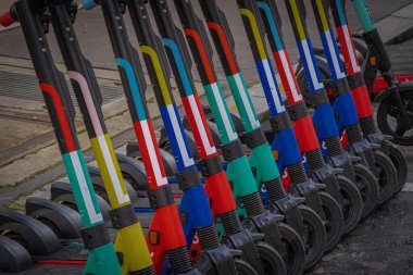 Paris, Fransa - 02 26 2021: Montmartre bölgesi. Bir sıra park halindeki renkli elektrikli scooter.