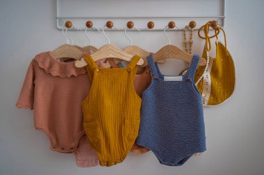 Asnieres-Sur-Seine, Fransa - 03 12 2021: Ahşap askılarda asılı renkli bebek kıyafetleri
