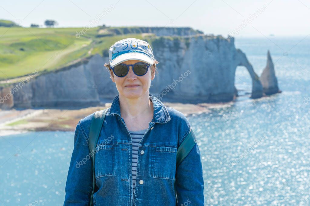Etretat, France - 05 31 2019: girl with cap and sunglasses on th