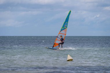 Langrune-Sur-Mer, Fransa - 08 05 2021: günbatımında sahilde yelken ve rüzgar sörfü