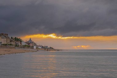 Langrune-Sur-Mer, Fransa - 08 05 05 2021: Gün batımında sahil kulübelerinin, iskelenin ve denizin manzarası