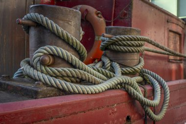 Paris, France - 10 11 2025: Ourcq Canal. Detail view of a red wooden boat hull with rope wound on capstans