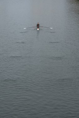 Paris, Fransa - 11 08 2025: Siyah giyinmiş bir adam Bassin de La Villette 'de kano kullanıyor.