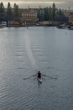 Paris, Fransa - 11 08 2025: Siyah giyinmiş bir adam Bassin de La Villette 'de kano kullanıyor.