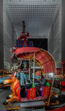 Paris, Fransa - Fransa - 12: 08 2025: Parvis de la Defense 'daki Noel pazarının Noel Baba, ren geyiği ve La Grande Kemeri' nin çocukları için kırmızı atlıkarıncalı görüntüsü