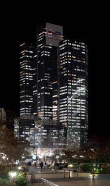 La Defense Paris, Fransa - 12 08 2025: La Defense bölgesi. Geceleri aydınlık bir gökdelen ve bahçe manzarası.