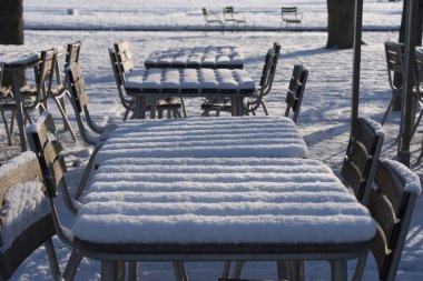 Paris, Fransa - 01 07 2026: kar taneleri. Tuileries bahçesindeki bahçe mobilyalarına bak. Karların ve güneşli mavi gökyüzünün altında.
