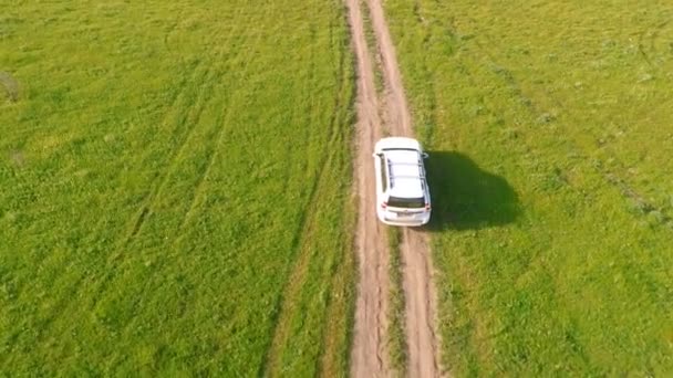 Вид с воздуха на движение внедорожника по сельской местности — стоковое видео