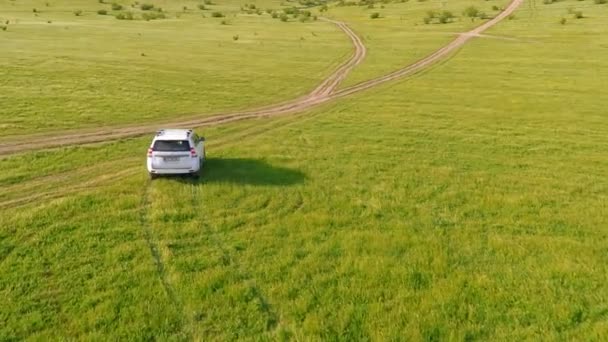 Вид с воздуха на движение внедорожника по сельской местности — стоковое видео