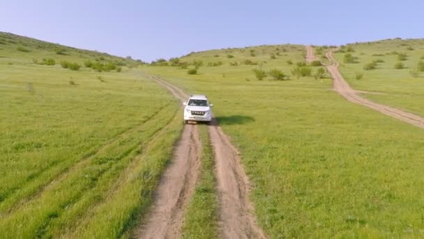 Vista aérea do carro que conduz offroad através do campo rural — Vídeo de Stock