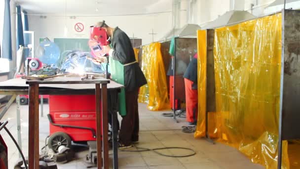 Mann schweißt Stahl in einer Fertigungsstraße, in einer Fabrik — Stockvideo