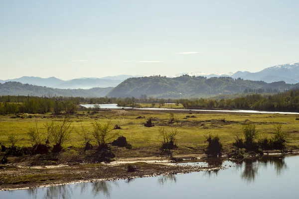 Mountain range with meadow near river — Stock Photo, Image