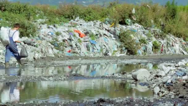 Homme marchant à travers les ordures dans la rivière 