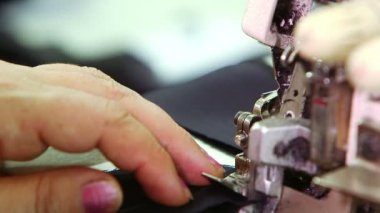 Female hands sews on sewing machine
