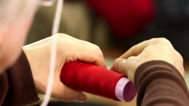 Female hands spins the thread on a spool — ストック動画