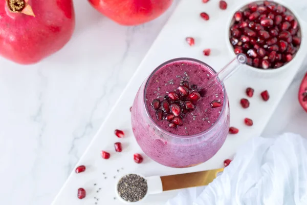 Beyaz mermer mutfak masasında chia tohumlu nar püresi. Üst Manzara. Kahvaltıda sağlıklı harmanlanmış içecek..