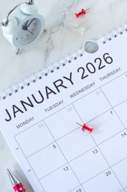 Kalem ve alarmlı takvim Ocak 2026. Üst Manzara. Yeni yıl kararları, yıllık planlama ve haftalık düzenleyici konsept.