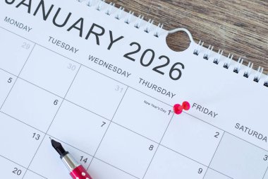 Ocak 2026 takvimi ve tahta masa üzerinde dolma kalem. Üst Manzara. Yıllık planlama, iş hedefleri ve karar kavramı.