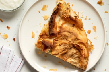 Mutfak masasında yoğurt ve ev yapımı Burek dilimi. Üst görünüm.