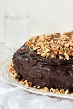 Cevizli çikolatalı pasta ve beyaz arka planda ev yapımı krema. Yakın plan. Uzayı kopyala Lezzetli vejetaryen tatlı yemeği.