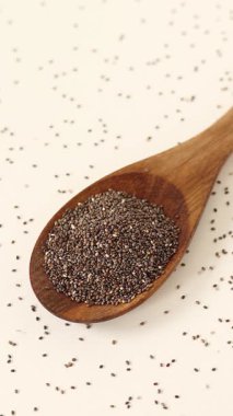 Tahta kaşığa chia tohumları döküyorum. Dikey video.