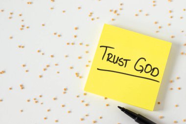 Tanrı 'ya güven, beyaz arka planda hardal tohumları olan el yazısıyla yazılmış bir alıntı. Üst Manzara. İsa 'ya inanmak, İncil kavramı.