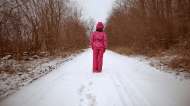 Pembe kışlık elbiseli kız. Kış karlı manzarası. Aktif yaşam tarzı. Seyahat.