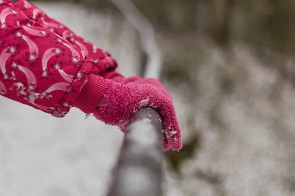 Pembe eldivenler. Kış. Tırabzanı tutan eller. Mevsimsel hava değişimi.