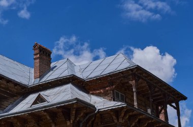 Eski ahşap evin tepesinde. Evin eski ahşap cephesi. Ahşap mimarinin eski ahşap evinin cephesi. 