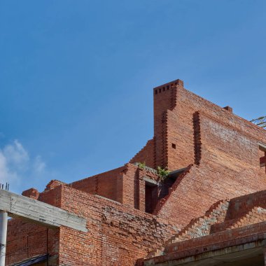 Bitmemiş tuğla inşaatı. Kırmızı tuğla yapımı. Tamamlanmamış bir evin kalıntıları..