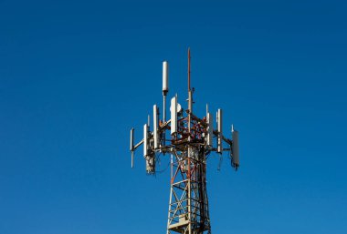 Telekomünikasyon GSM (5G, 4G) kulesinin tepesindeki teknoloji kopyalandı. Bir binanın çatısındaki cep telefonu antenleri.